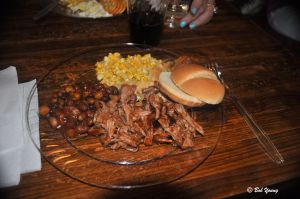 Plated pulled pork, homemade beans and corn pie.