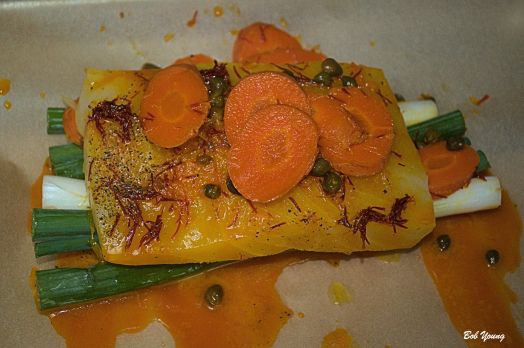 The halibut is being prepared for the parchment wrap.