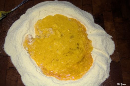 First. Make a hole in the center of your flour - I used Semolina. Add the eggs and the egg yolk, oil - I used a garlic infused olive oil - salt and 1 or 2 T water.