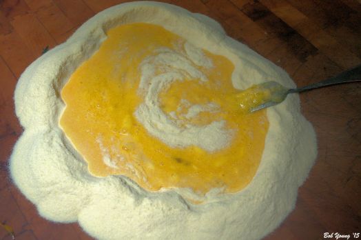 Pulling the semolina into the egg mixture using a fork. Work carefully.