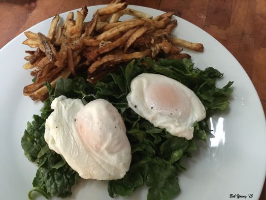 Chopped Raw Spinach Topped with Two Soft Cooked Eggs and served with French Fries.