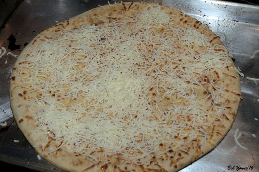 Cheese on pizza dough waiting for the shrimp