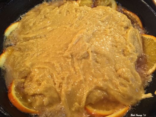 Cake batter is poured on top of the carmalized oranges.